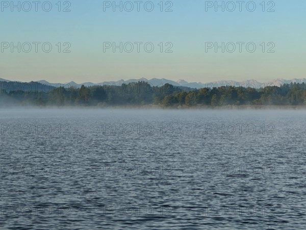 Light fog over Lake Starnberg with a view of the Alps, Bavaria, Germany