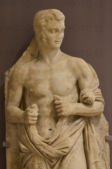Marble sculpture of a half-naked man, draped in a cloth, classically leaning, Archaeological Museum, Kos Town, Kos, Dodecanese, Greek Islands, Greece