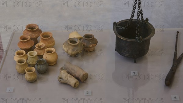 Collection of ancient ceramic artefacts, various pots and a metal crucible on display, Archaeological Museum, Kos Town, Kos, Dodecanese, Greek Islands, Greece