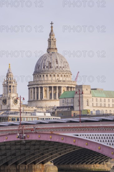 Bridge in front of a large cathedral with distinctive dome and towers, London, United Kingdom, World