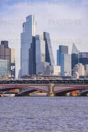 Modern skyscrapers on the river and a large bridge in the foreground, London, United Kingdom, World