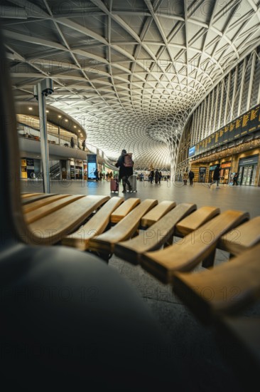 Modern station concourse with eye-catching ceiling patterns and people in a lively atmosphere, King's Cross Station, London, United Kingdom, World