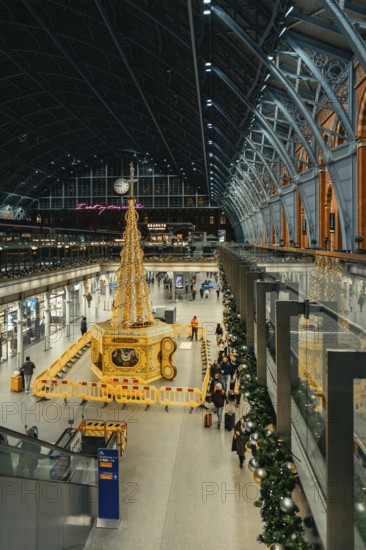 Christmassy decorated station hall with large tree sculpture and lots of people, London, United Kingdom, World