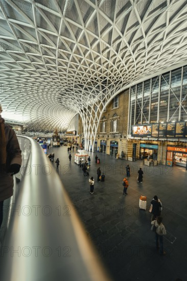 Large, modern train station with impressive glass roof and scattered travelers, King's Cross Station, London, United Kingdom, World