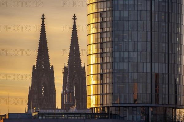 Cologne Cathedral, church towers, round façade of the Cologne Triangle Hochaus in Cologne-Deutz, sunset, North Rhine-Westphalia, Germany