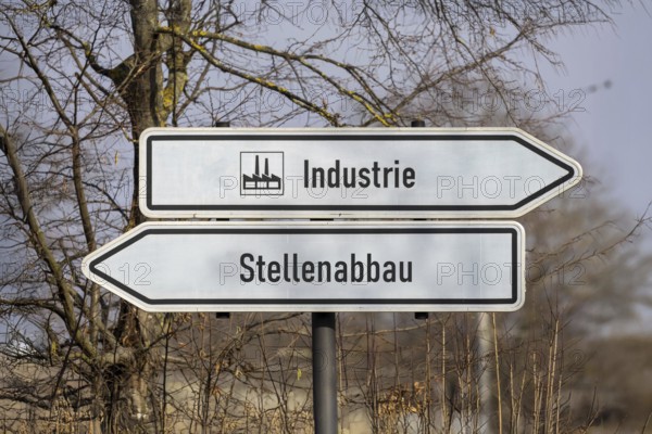 (photo montage) Directional arrows with the inscription INDUSTRY and JOB CUTS