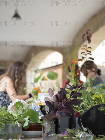 Florists arranging flowers during an ikebana workshop, learning traditional japanese art