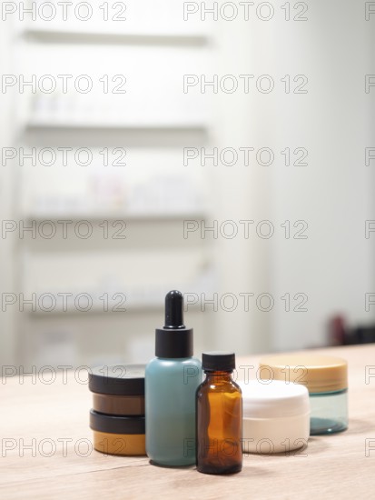 Skincare bottles and jars standing on wooden table with minimalist background