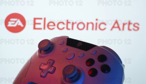 Dhaka, Bangladesh- 24 Mar 2025: A close-up of a gamepad with the Electronic Arts seen on screen in the background