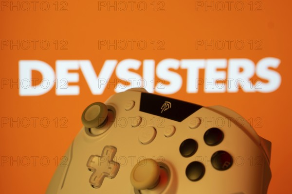Dhaka, Bangladesh- 20 Mar 2025: A close-up of a gamepad with the Devsisters seen on screen in the background