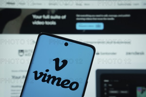 Dhaka, Bangladesh - 17 March 2025: The logo of the Vimeo is displayed on a smartphone screen, and the website is visible on a computer screen in the background