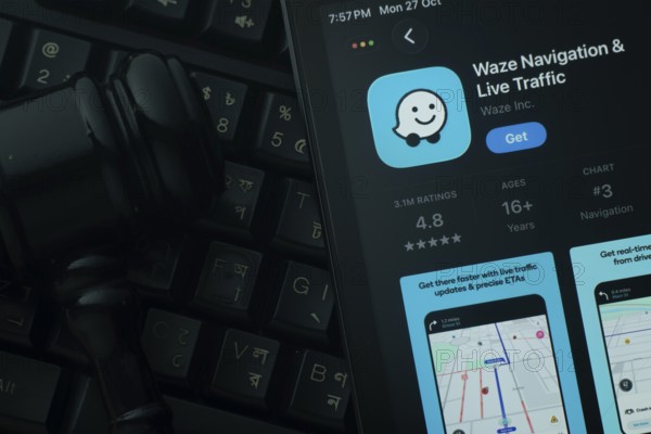 Dhaka, Bangladesh- 28 Oct 2025: An iPad displaying the Waze app against a judge's gavel and dark keyboard background