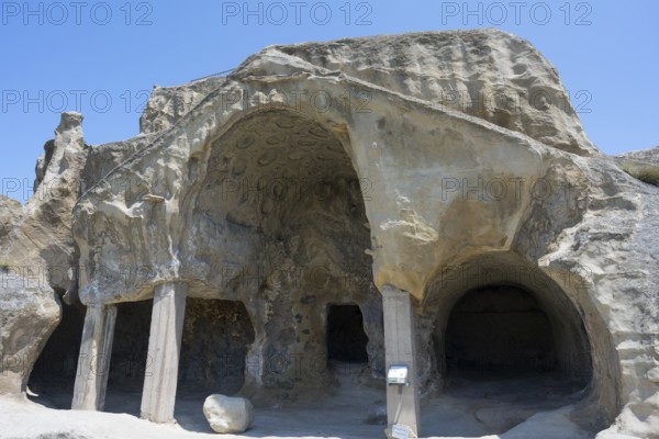 Ancient cave architecture with stone entrances and a clear sky, cave opening with gable fragment, cave town Uplistsikhe, Inner Kartli region, Shida Kartli, Georgia