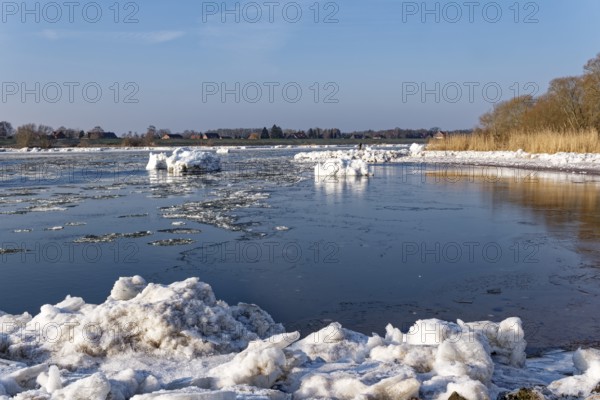 Ice flow on the Elbe in the area of the federal waterway near Geesthacht on a clear winter day. Small icebergs float downstream. Geesthacht, Schleswig-Holstein, Germany