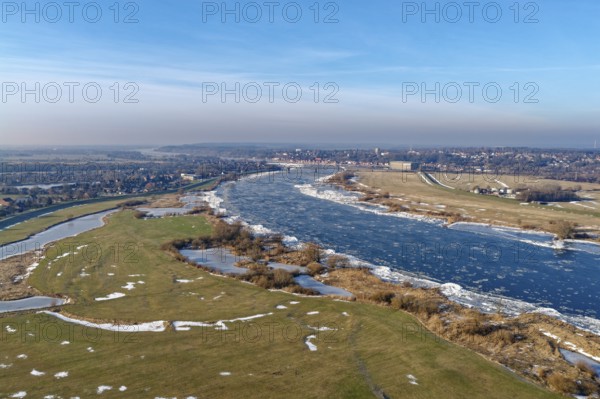 Icy riverbanks of the Elbe and ice in the foothills of the Elbe near Hohnstorf, Lüneburg district, on a cold winter day. In the background, the city of Lauenburg. aerial view. Hohnstorf, Lower Saxony, Germany
