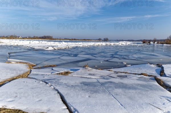Ice on the banks of the Elbe and remnants of snow in the foothills of the Elbe on a clear winter day. Hohnstorf, Lüneburg District, Lower Saxony, Germany