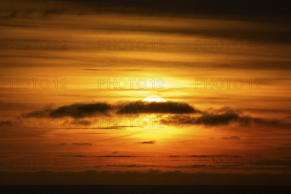 Sunset behind clouds, Baltic Sea
