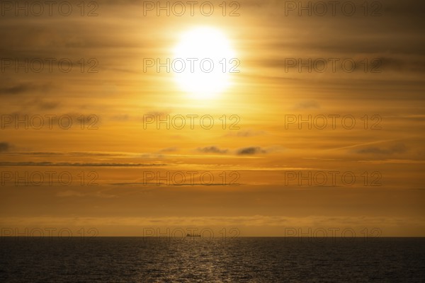 Silhouette, cargo ship on the horizon, sunset, Baltic Sea