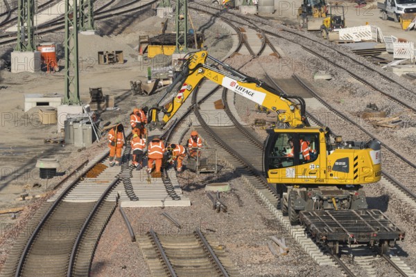 Construction workers wearing orange safety clothing during track repairs on a construction site, Untertürkheim parking station, Stuttgart, Baden-Württemberg, Germany