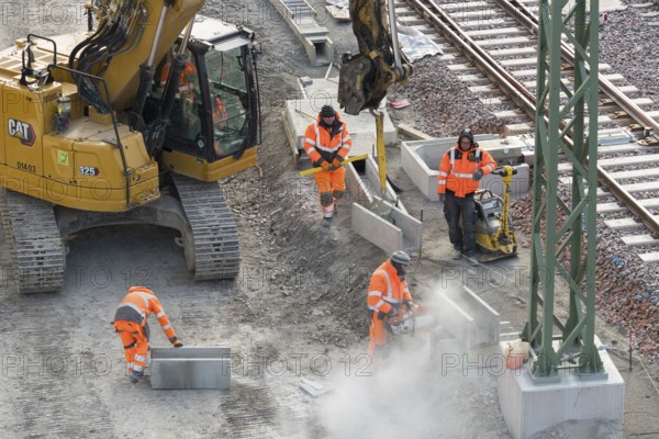 Construction workers use construction machinery to lay rail structures, cutters, vibrators, Untertürkheim parking station, Stuttgart, Baden-Württemberg, Germany