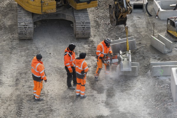 Construction site workers use a power grinder in an urban environment next to an excavator, Untertürkheim parking station, Stuttgart, Baden-Württemberg, Germany
