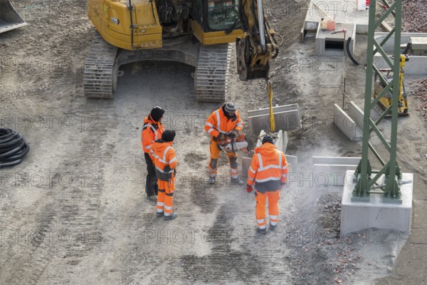 Workers wearing safety clothing use cutters near excavators on construction site, Untertürkheim parking lot, Stuttgart, Baden-Württemberg, Germany
