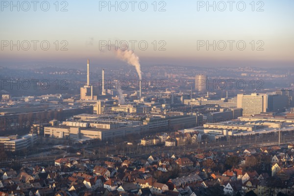 Aerial view of a city at dusk, with industrial structures and suburban houses, sky and smoke visible, view of Daimler Group headquarters, Untertürkheim plant, Stuttgart, Baden-Württemberg, Germany