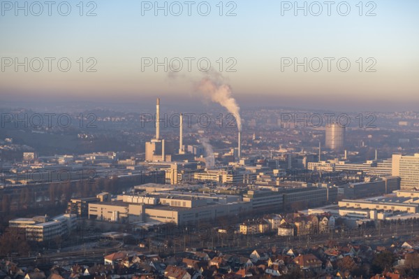 City view at dusk, modern buildings in the foreground, chimneys with smoke and a calm atmosphere in the sky, view of Daimler headquarters, Untertürkheim plant, Stuttgart, Baden-Württemberg, Germany