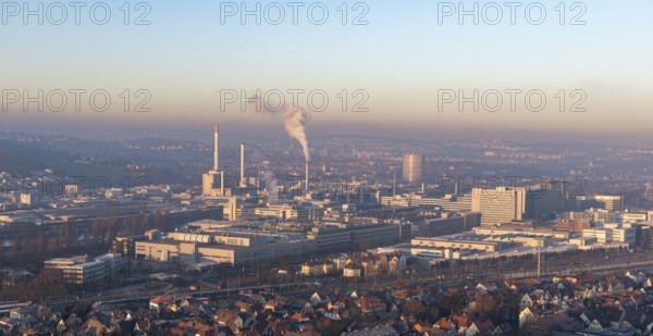 Extensive city view at sunrise with industrial plants and smoke developments, view of Daimler Group headquarters, Untertürkheim plant, Stuttgart, Baden-Württemberg, Germany
