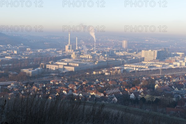 View of a city in morning light with industrial buildings and smoke from chimneys, Daimler headquarters, Untertürkheim plant, Stuttgart, Baden-Württemberg, Germany