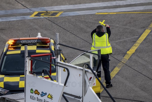 Instructor, apron supervision, an aircraft, after landing, at the parking position, at the terminal, gates, at the passenger bridge, Cologne/Bonn airport, CGN, North Rhine-Westphalia, Germany