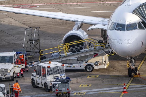 Baggage unloading of an aircraft, at the parking position, at the terminal, gate, at the passenger bridge Cologne/Bonn Airport, CGN, North Rhine-Westphalia, Germany