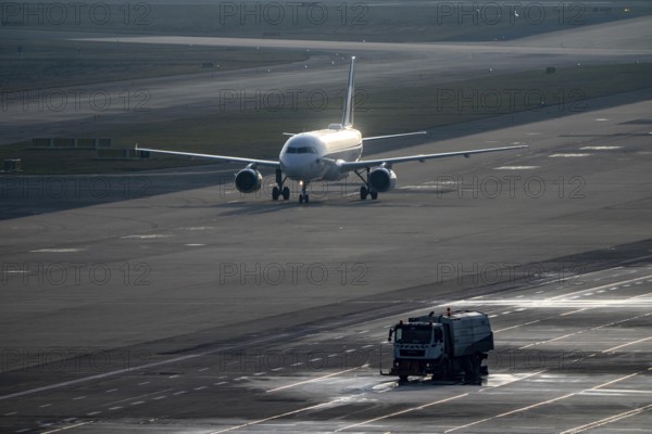 Eurowings Airbus after landing on the taxiway to terminal, at Cologne/Bonn airport, CGN, road sweeper cleans the apron, North Rhine-Westphalia, Germany