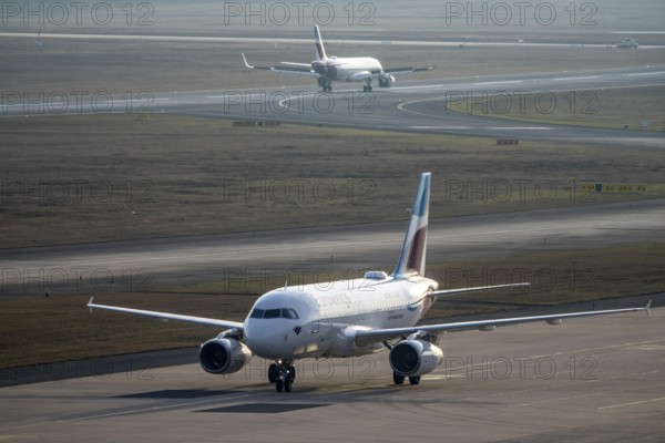 Eurowings Airbus after landing on the taxiway to the terminal, plane taking off, to Cologne/Bonn Airport, CGN, North Rhine-Westphalia, Germany