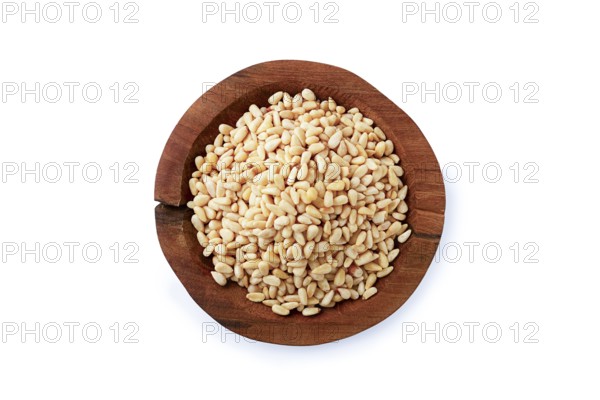 Peeled pine nuts, in a wooden bowl, on a white background, isolate, close-up, no people