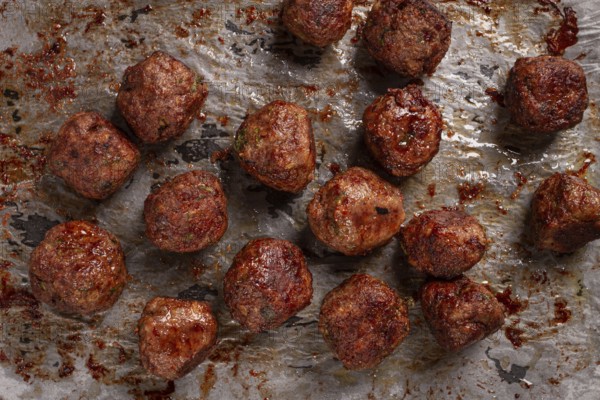 Homemade meatballs cooked to perfection on a baking tray with seasoning and herbs, Swedish meatballs