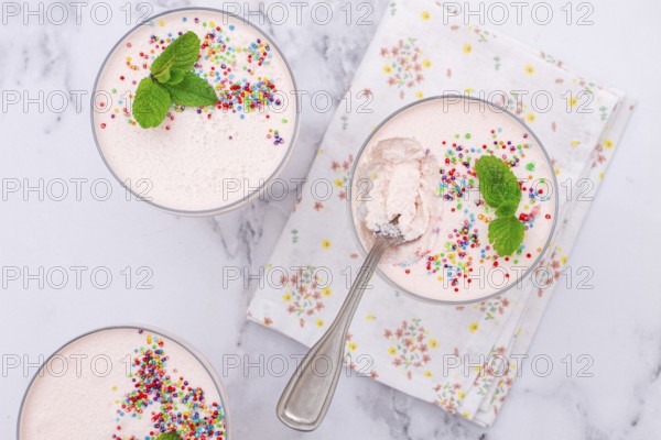Fruit mousse, made from jelly and cottage cheese, in glasses, decorated with sprinkles and mint, homemade
