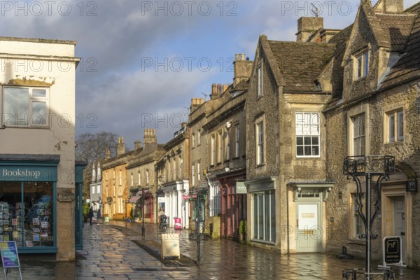 Wet pavements after rain in pedestrianised High Street are of town centre of Corsham Wiltshire, England, UK - quiet, few people