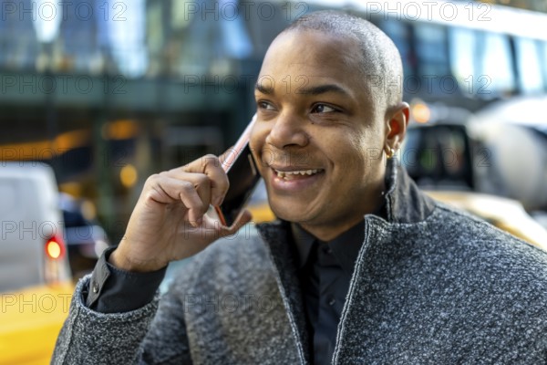 Smiling businessman in a suit hails manhattan streets while talking on his smartphone, engaged in a confident workday conversation during a busy new york city commute