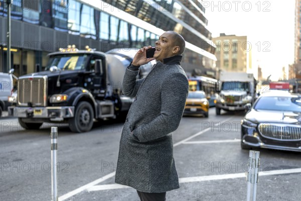 Smiling businessman talking on his mobile while walking a busy manhattan street, illustrating urban connectivity, modern professional life, networking and confident city mobility