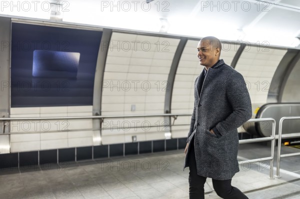 Businessman smiling and walking purposefully through a modern subway station, feeling confident and preparing for a busy day in the urban environment of manhattan, new york