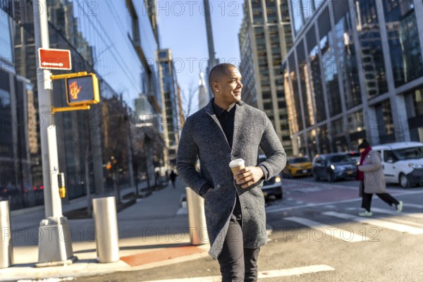 Young man in a stylish coat walks manhattan streets holding a coffee, confidently navigating between glass buildings modern urban professional life and busy commute
