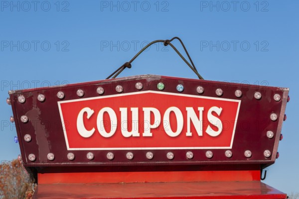 Close-up of the word coupons spelled out in bold white letters on red and maroon colored banner, Quebec, Canada