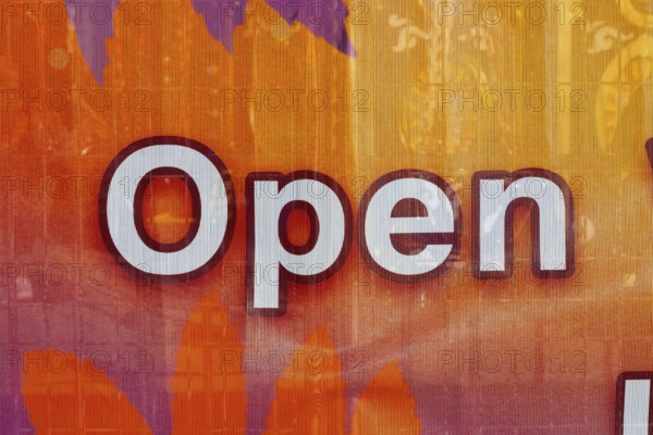Close-up of the word open spelled out in white letters outlined in maroon color on textile banner, Quebec, Canada
