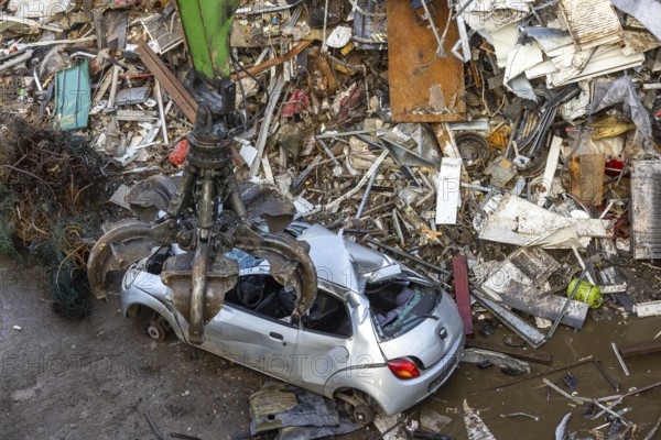 Scrap trade in a commercial port. A disused small car is scrapped. Mannheim, Baden-Württemberg, Germany
