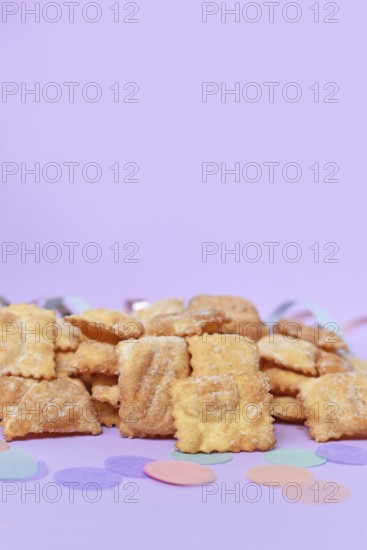Rhenish pastries called 'Mutzen pastries or Muzenblätter' with powdered sugar on festive background. Traditional German carnival and Fasching fried pastry