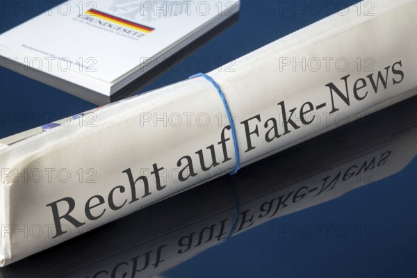 Symbolic newspaper with the headline RIGHT TO FAKE NEWS, with the German constitution in the background