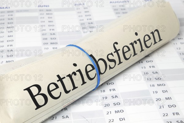 Betriebferien: Symbolic newspaper with the inscription COMPANY HOLIDAYS on a calendar