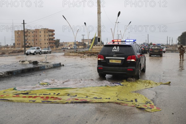 In Raqqa, Syria on January 18, 2026, a convoy of Syrian Government forces is seen advancing through the region, treading over flags of the Syrian Democratic Forces (SDF). This movement comes as government troops successfully take control of dozens of towns and villages across Northeast Syria following the withdrawal of Kurdish-led groups affiliated with the PKK, Raqqa, Tabqah, Syria
