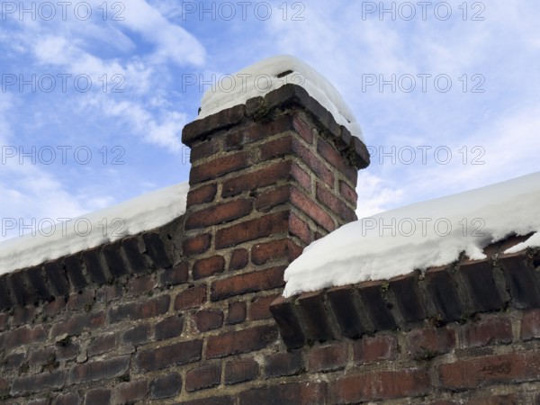 Snowy brick wall against blue winter sky, Wuppertal, Germany